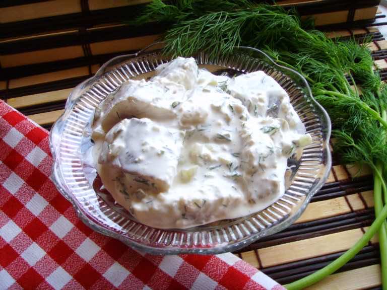 Śledzie w sosie czosnkowo-koperkowym z ogórkiem i cebulką.