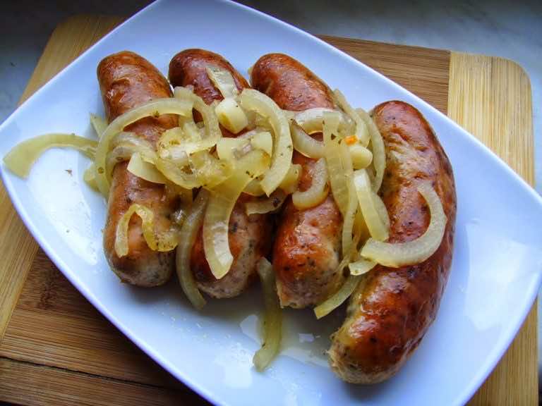 Biała kiełbasa pieczona w piwie z cebulą i majerankiem.