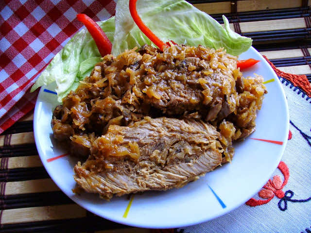 Karkówka pieczona w kapuście kiszonej z pieczarkami.