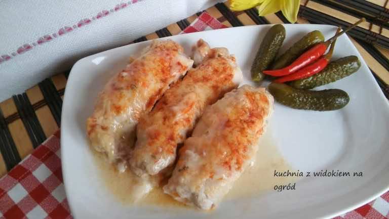 Roladki schabowe z szynką i serem zapiekane w sosie serowym.
